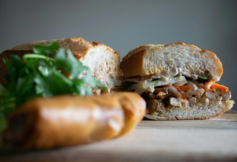 banh mi with green vegetable on brown wooden table