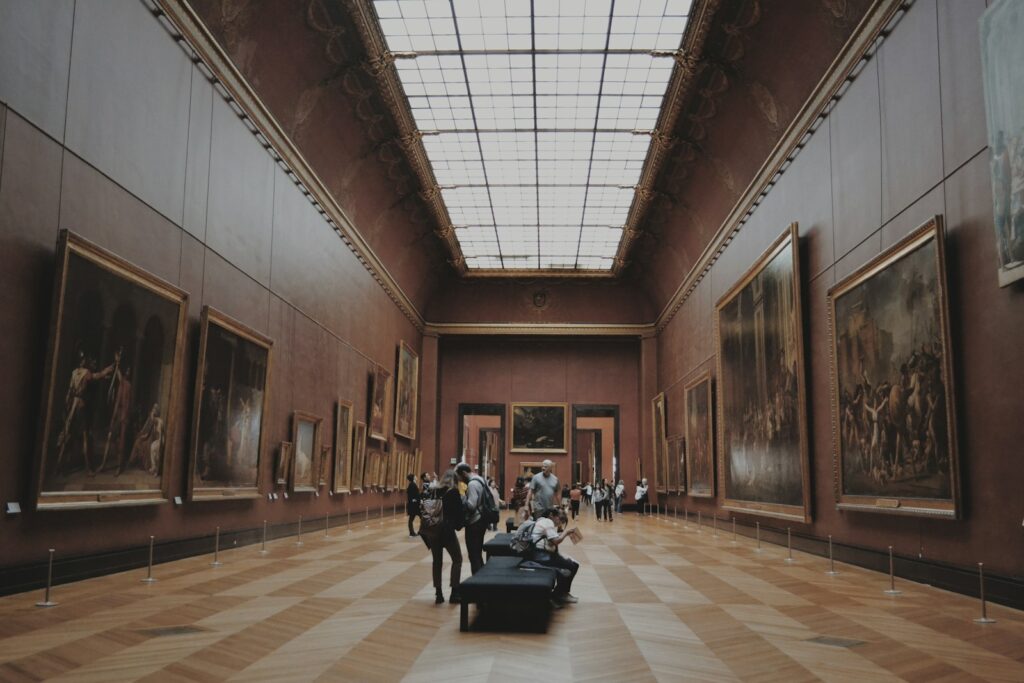 people walking on museum looking at painting